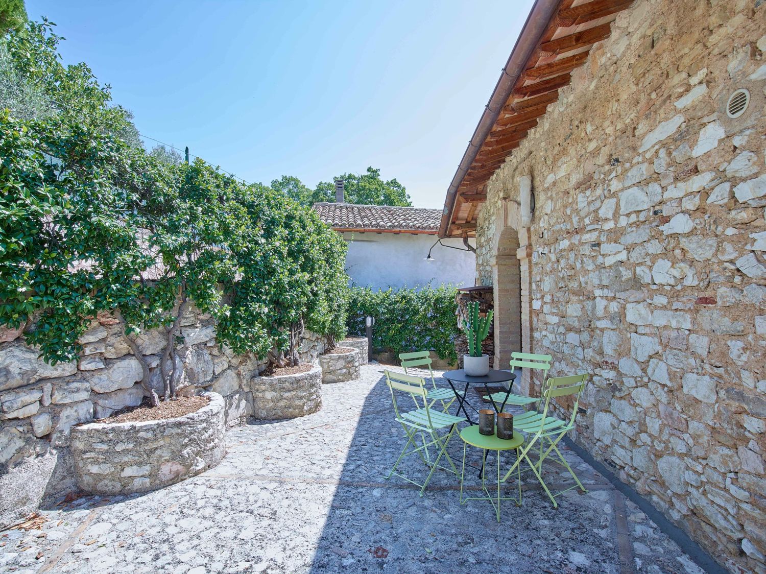 Stone courtyard with mint green chairs by the front door