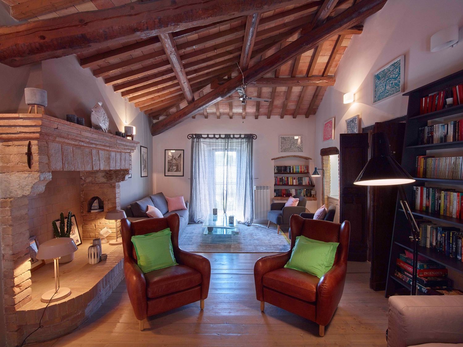 Upstairs living room with leather armchairs, stone fireplace and beamed ceiling