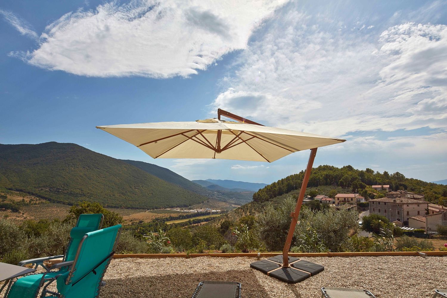 Parasol and reclining chairs facing the valley