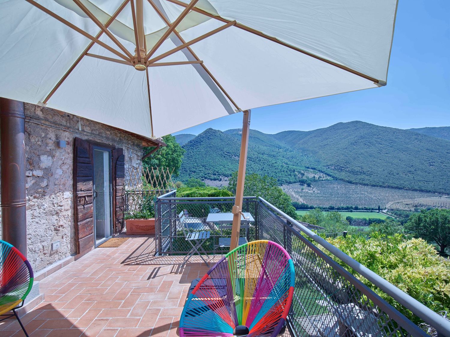 Terrace chairs looking over olive groves to the hills